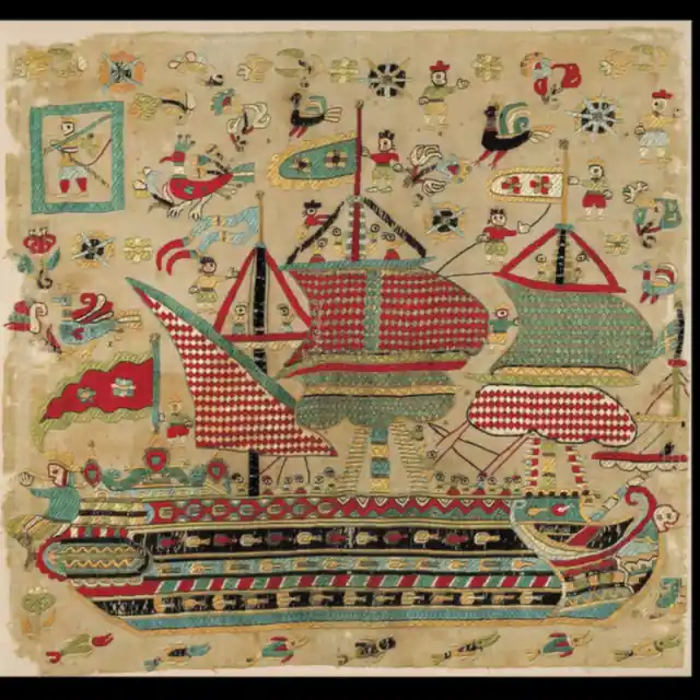 Embroidered cushion face showing a sailing ship stitched in red, green and cream on linen
